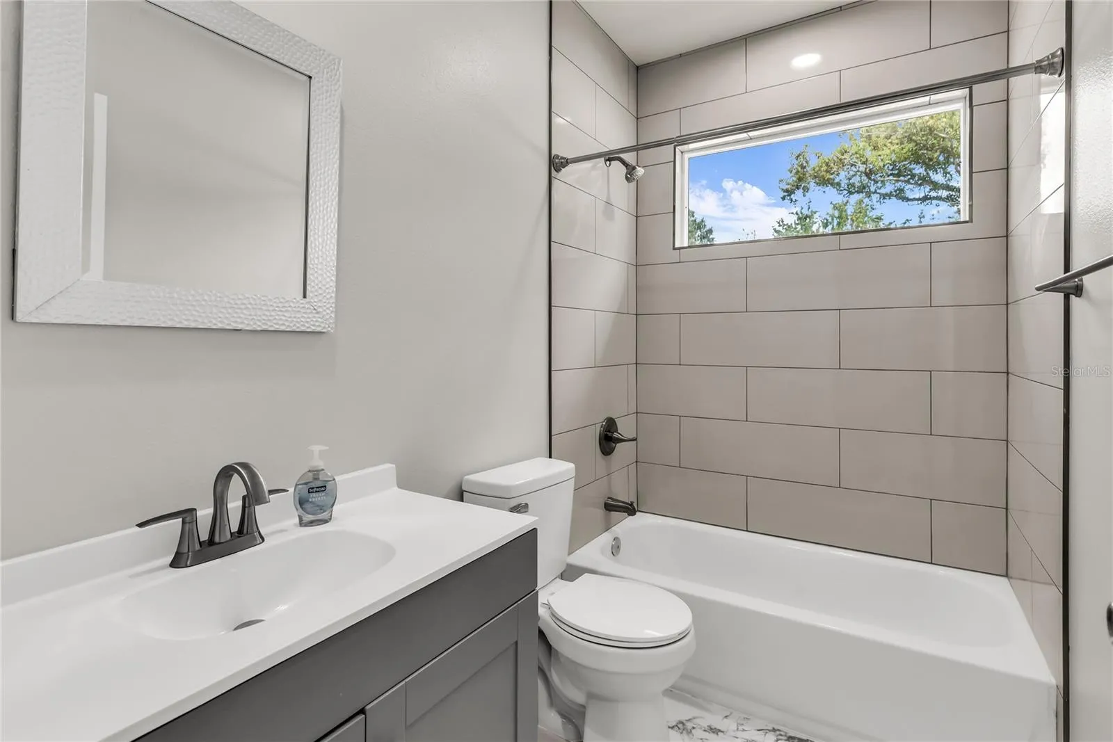 Hallway Bath features modern vanity, fixtures and tiled shower/tub combo