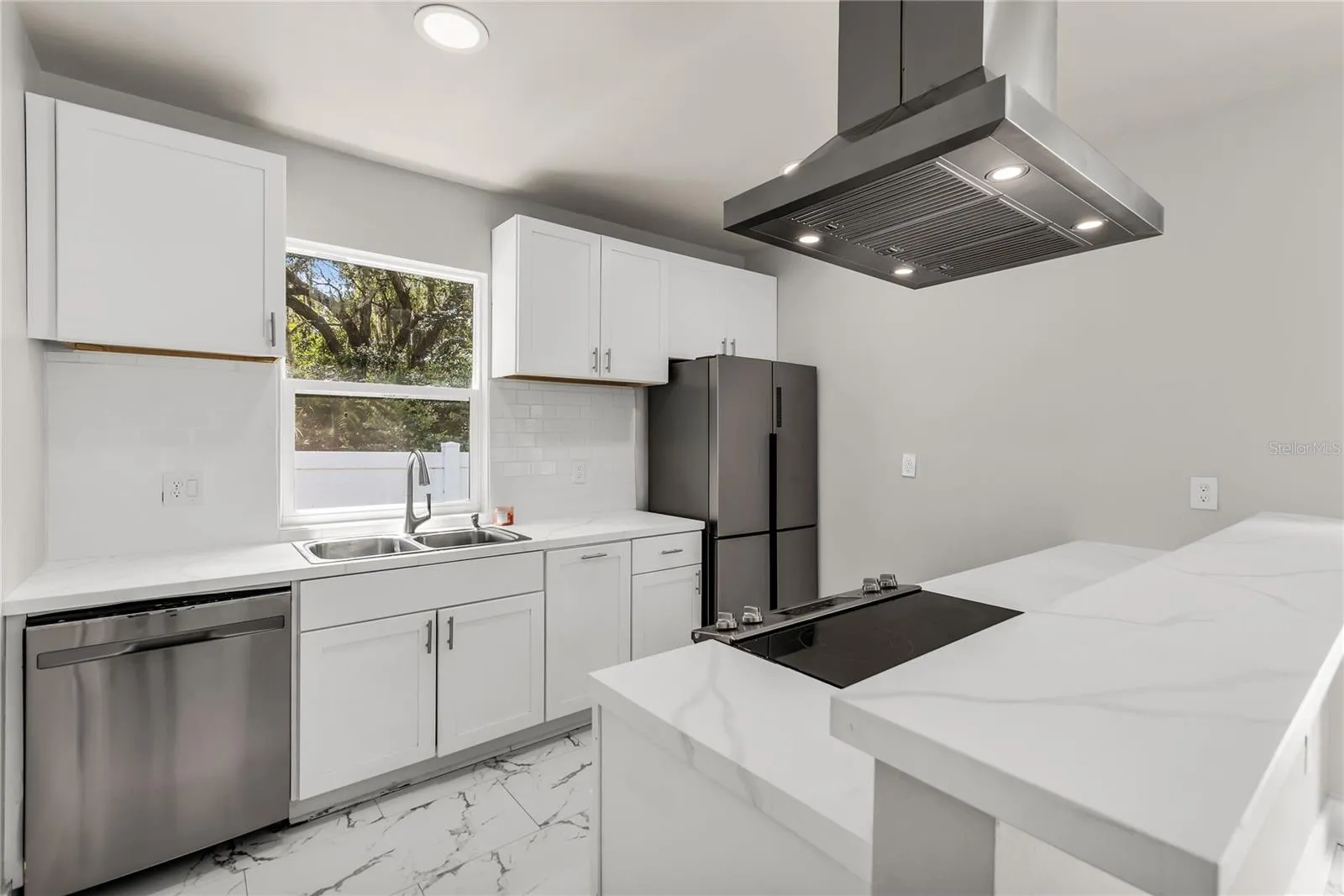 Kitchen features granite countertops, modern subway tile backsplash and stainless steel appliances.