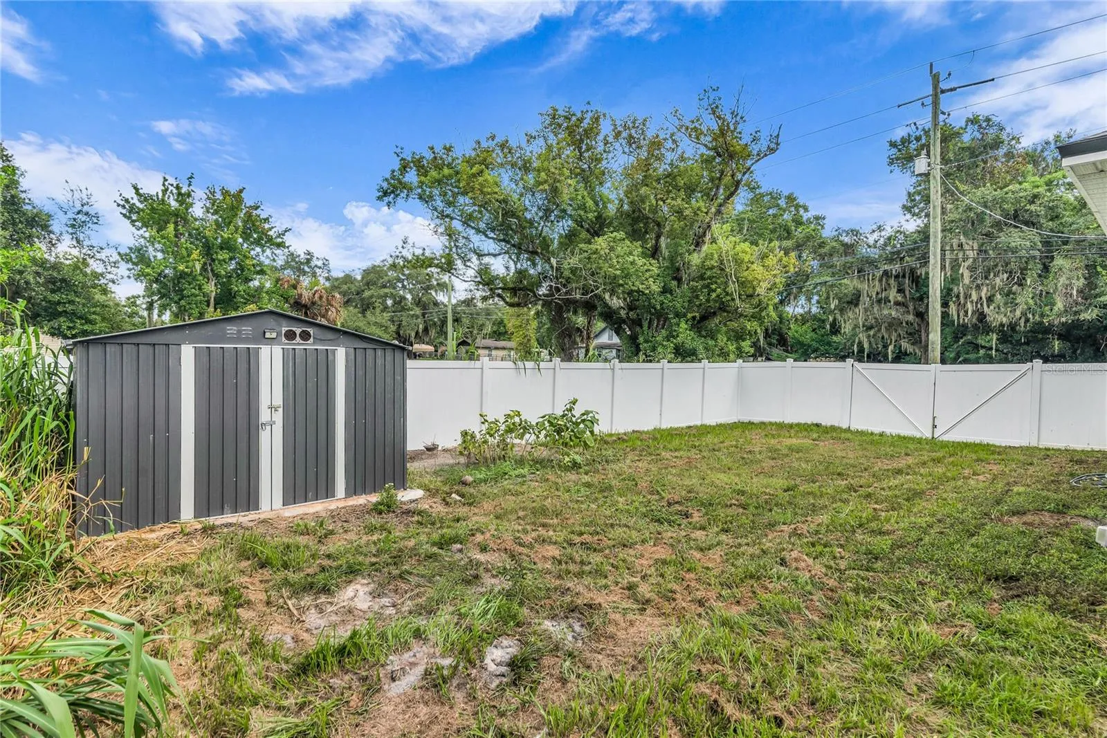 Fully fenced in back yard with storage shed