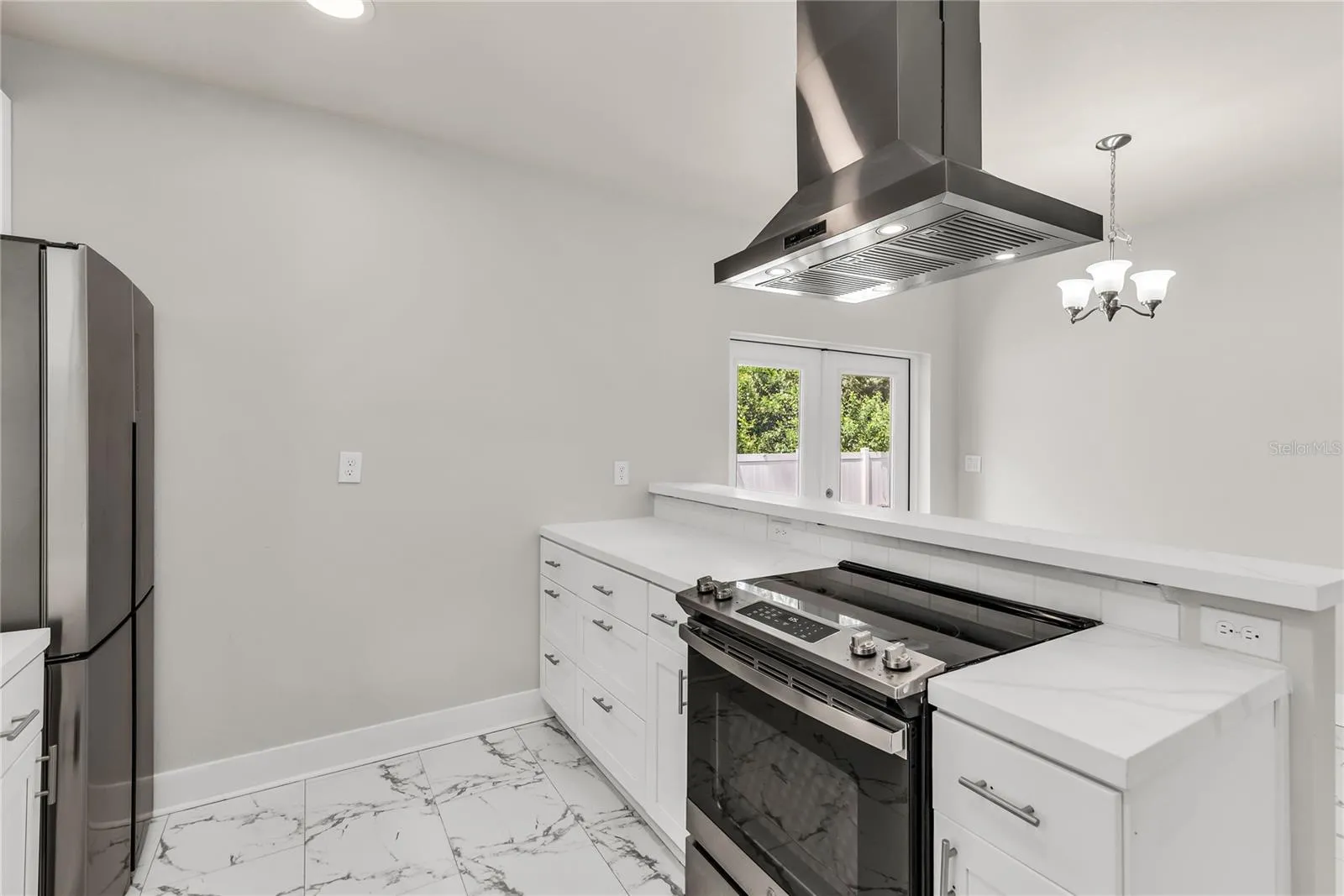 Kitchen features granite countertops, modern subway tile backsplash and stainless steel appliances.