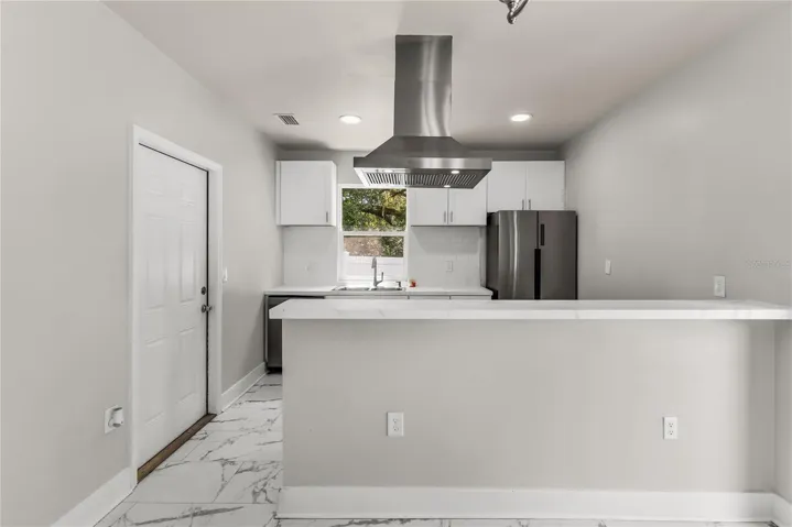 Kitchen features granite countertops, modern subway tile backsplash and stainless steel appliances.