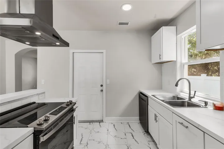 Kitchen features granite countertops, modern subway tile backsplash and stainless steel appliances.