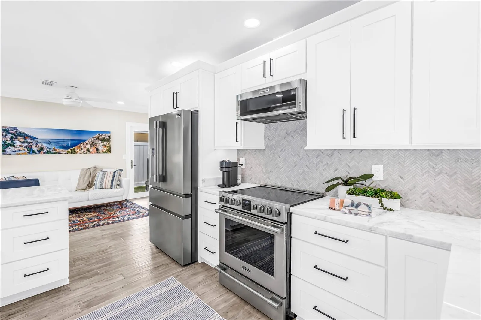 Stainless appliances, range with convection and air fryer functions, deep storage drawers and a herringbone shell tile backsplash.