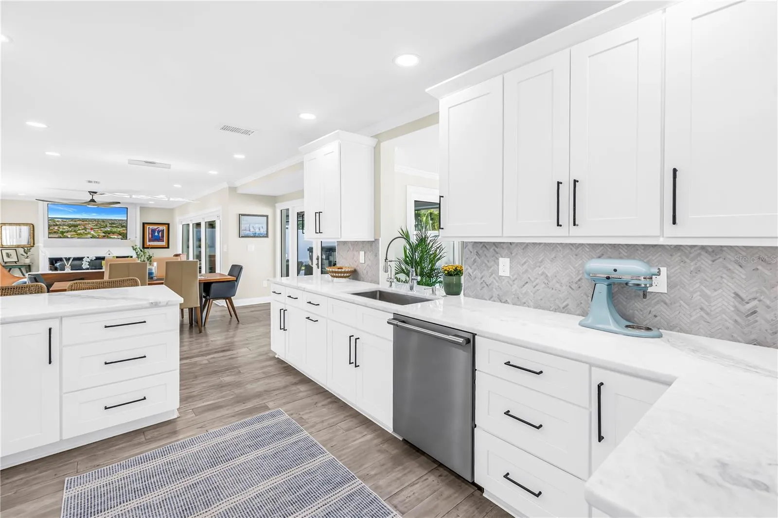 White Shaker cabinetry with upper and lower molding details and under counter lighting.