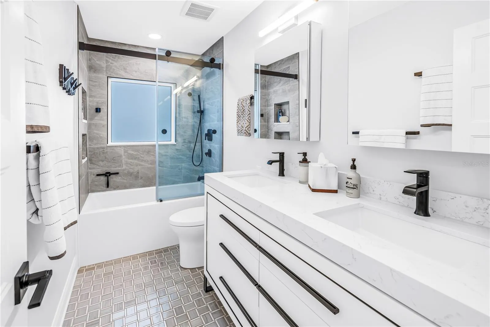 2nd bath with deep soaking tub, custom dual vanity with European style drawers, stone countertops, 2  Robern medicine cabinets, frosted glass window for natural light and comfort height European style flush toilet.