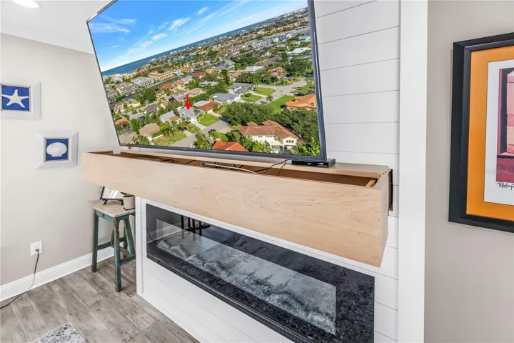 Custom mantel is an A/V storage drawer over the electric fireplace.