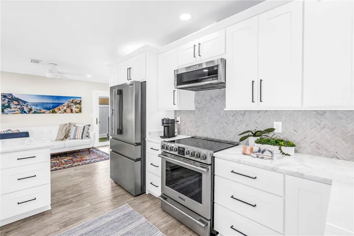 Stainless appliances, range with convection and air fryer functions, deep storage drawers and a herringbone shell tile backsplash.