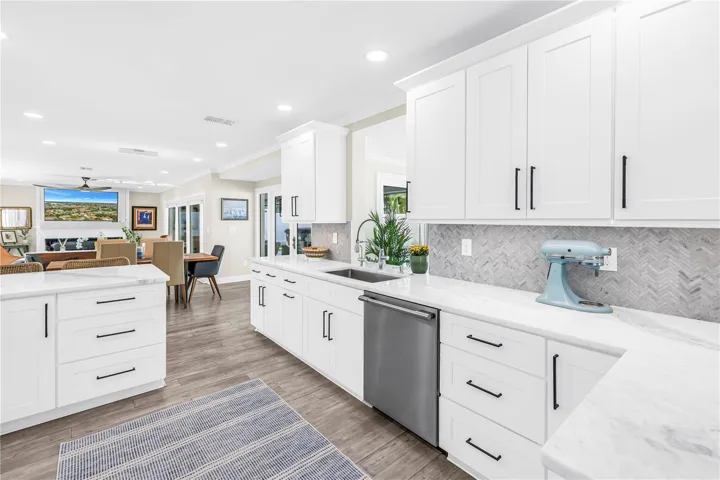 White Shaker cabinetry with upper and lower molding details and under counter lighting.