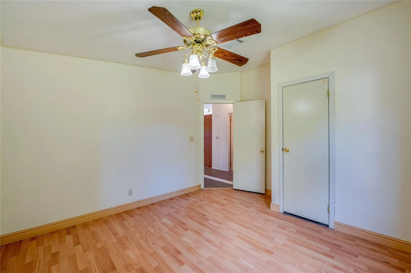 Alternate view highlights the room’s comfortable proportions, ceiling fan, and convenient closet storage.