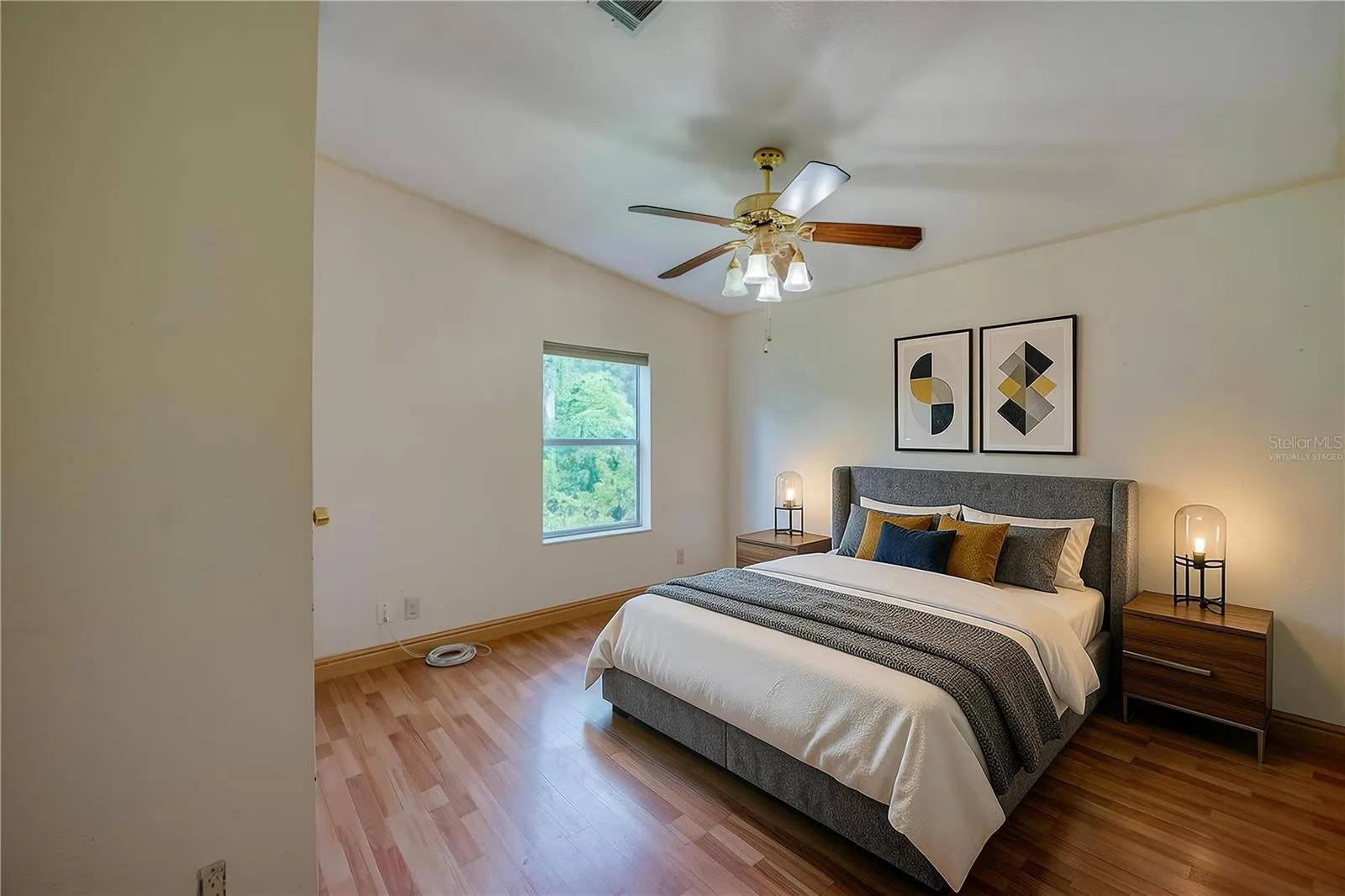 Virtually Staged...Spacious bedroom offers a ceiling fan, natural light from a large window, and ample wall space for flexible furniture placement.