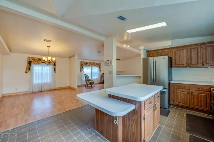 View from the kitchen highlights the center island and the open connection to the adjacent dining and living areas.