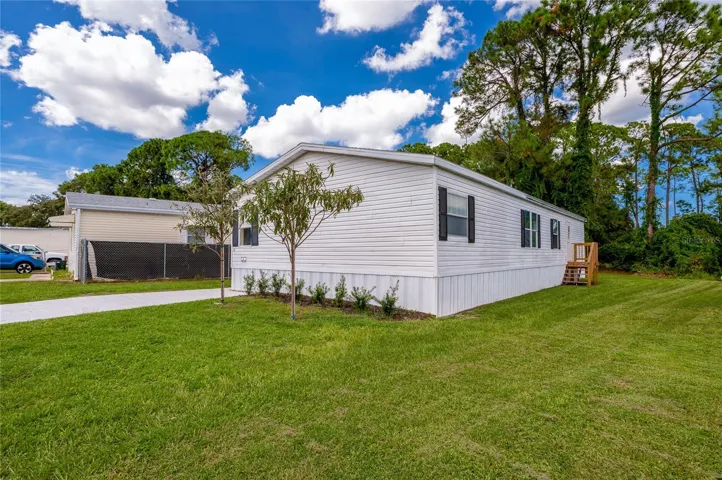 Well-kept exterior with light siding, contrasting shutters, fresh landscaping, and a spacious lawn surrounding the home.