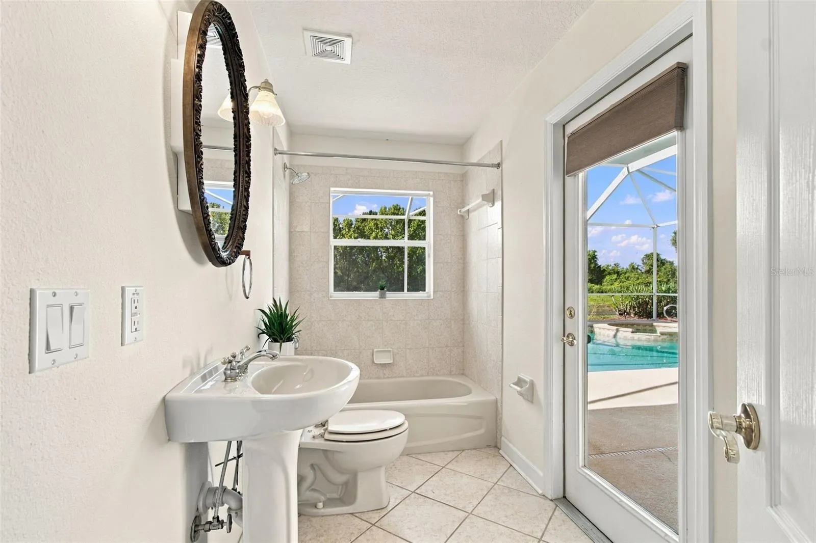 Secondary bathroom with easy access to the pool, spa and outdoor screened lanai.