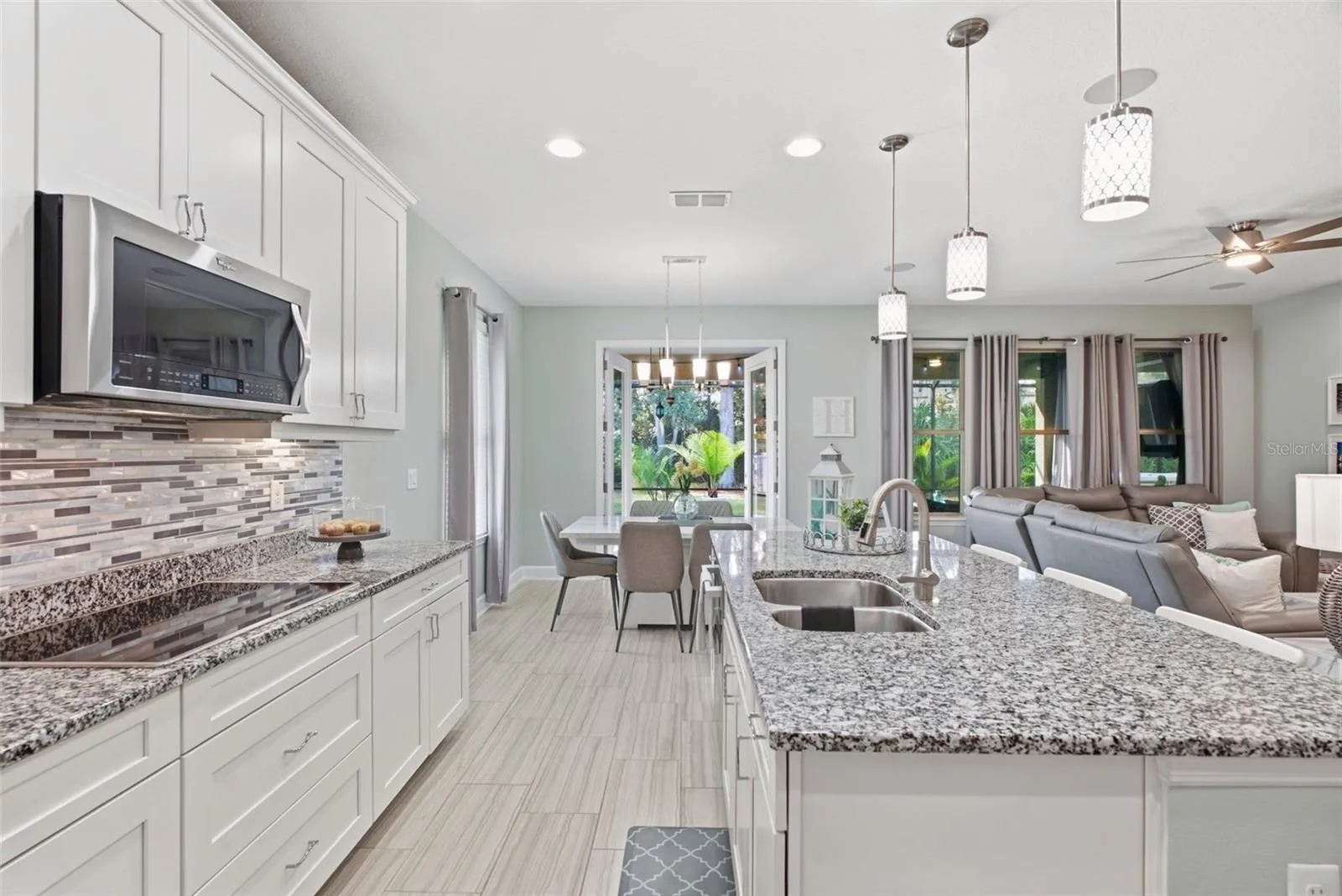 Gourmet kitchen anchored by a large island with seating for three and glass French doors leading to the patio