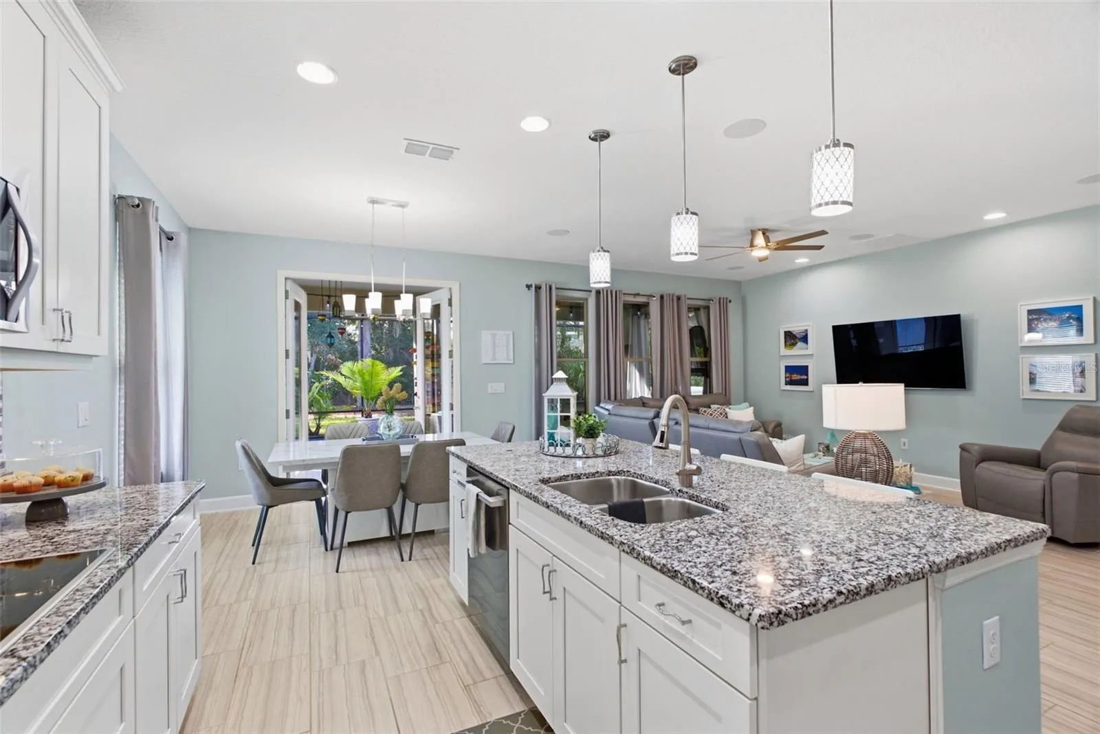 Living room and kitchen flow together, with French doors open to the lanai
