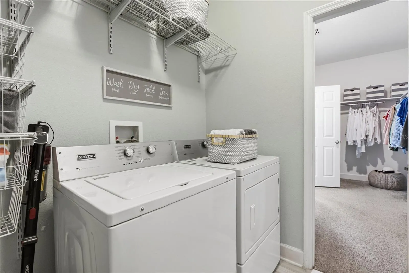 Laundry room with access to primary walk in closet