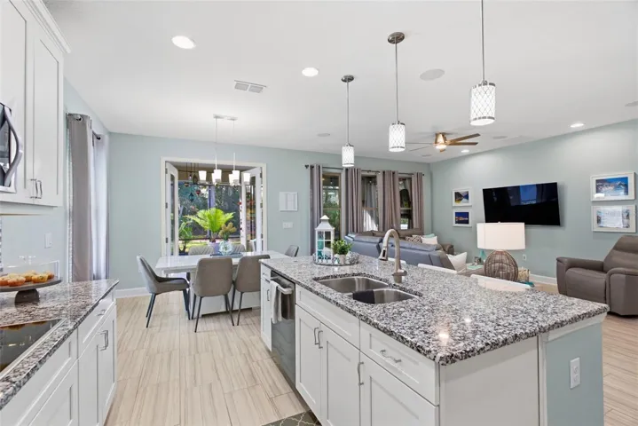 Living room and kitchen flow together, with French doors open to the lanai
