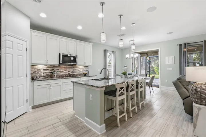 Living room and kitchen flow together, with French doors open to the lanai