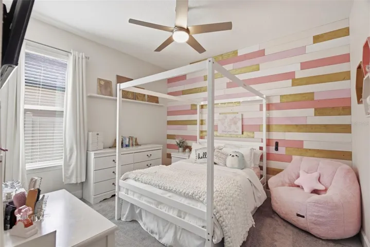 Inviting bedroom 2 featuring a stylish custom accent wall behind the bed and new carpet