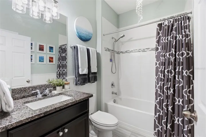 Well-appointed secondary bathroom featuring granite countertops