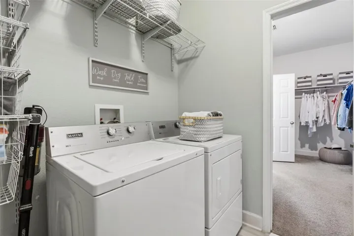 Laundry room with access to primary walk in closet