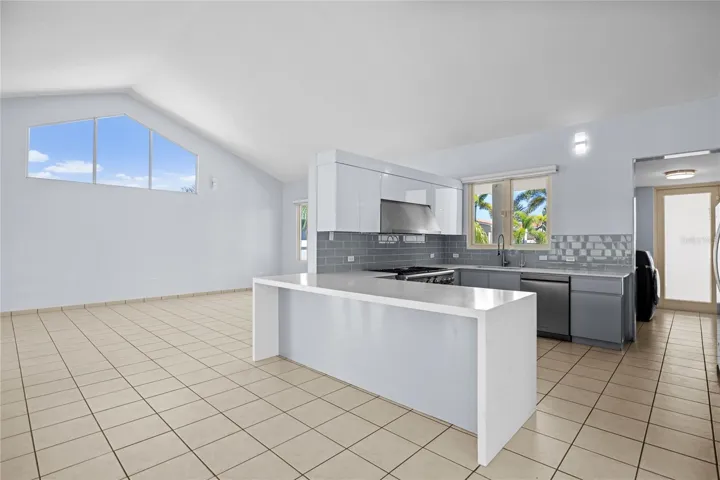 Renovated kitchen designed for everyday living and entertaining, featuring updated cabinetry, a gas range, and a wine refrigerator.