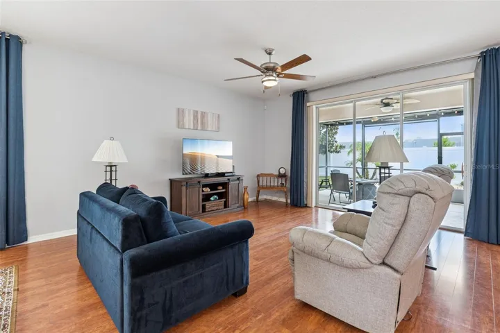 The spacious Living Room is enhanced with triple glass sliding doors that open to the extended lanai, seamlessly blending indoor and outdoor living.