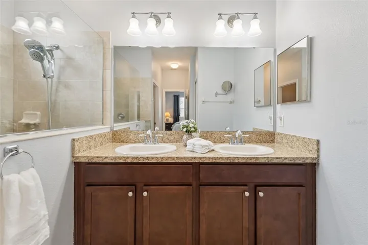 Primary Bath features a comfort height vanity with dual sinks, linen closet and a water closet