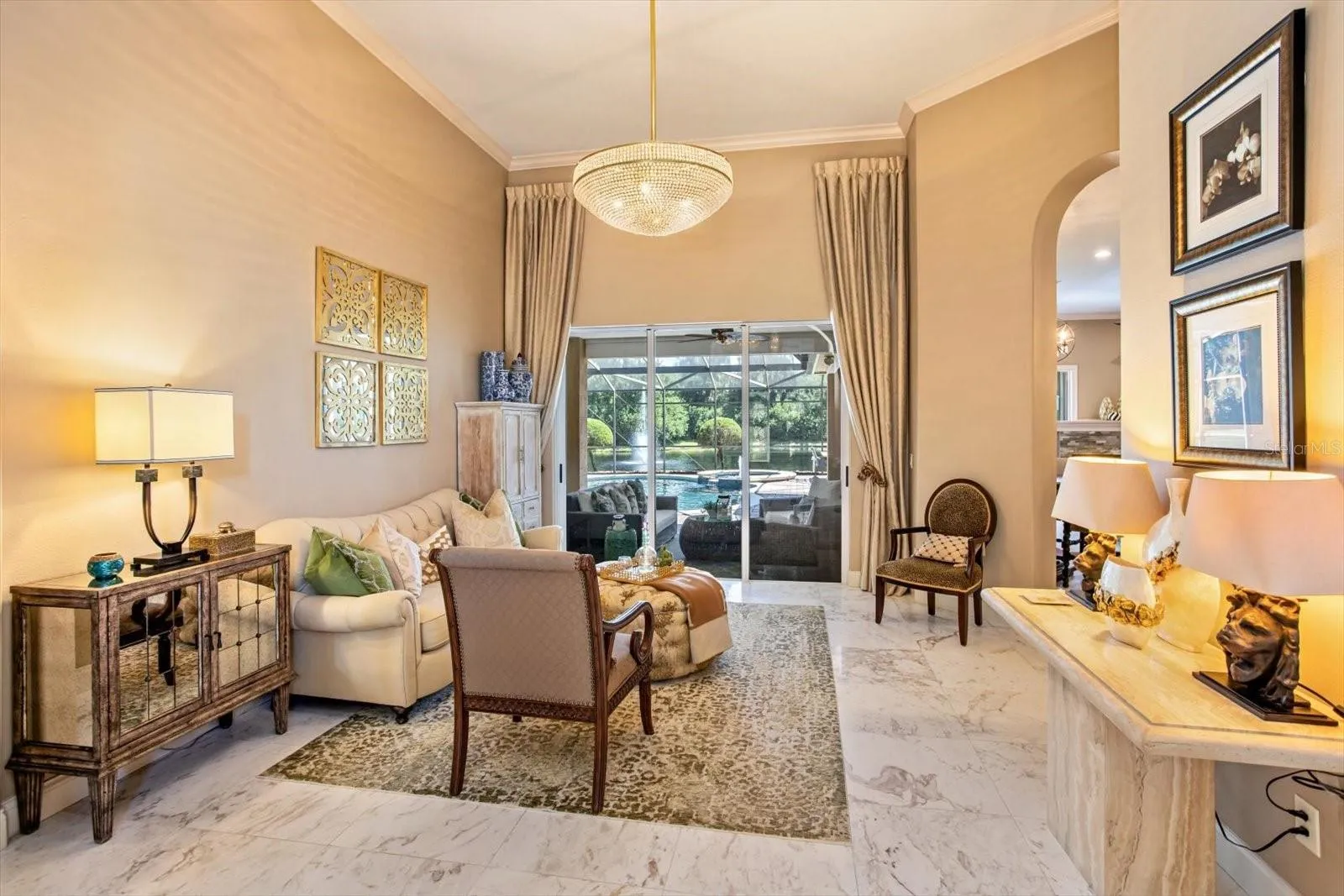Living Room soaring ceilings and view to pool, pond and lanai