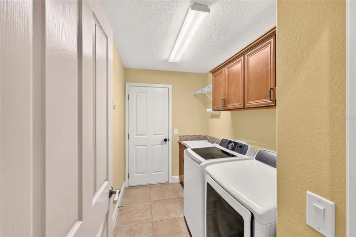 Inside Laundry Room with Utility Sink, Cabinets & Washer/Dryer