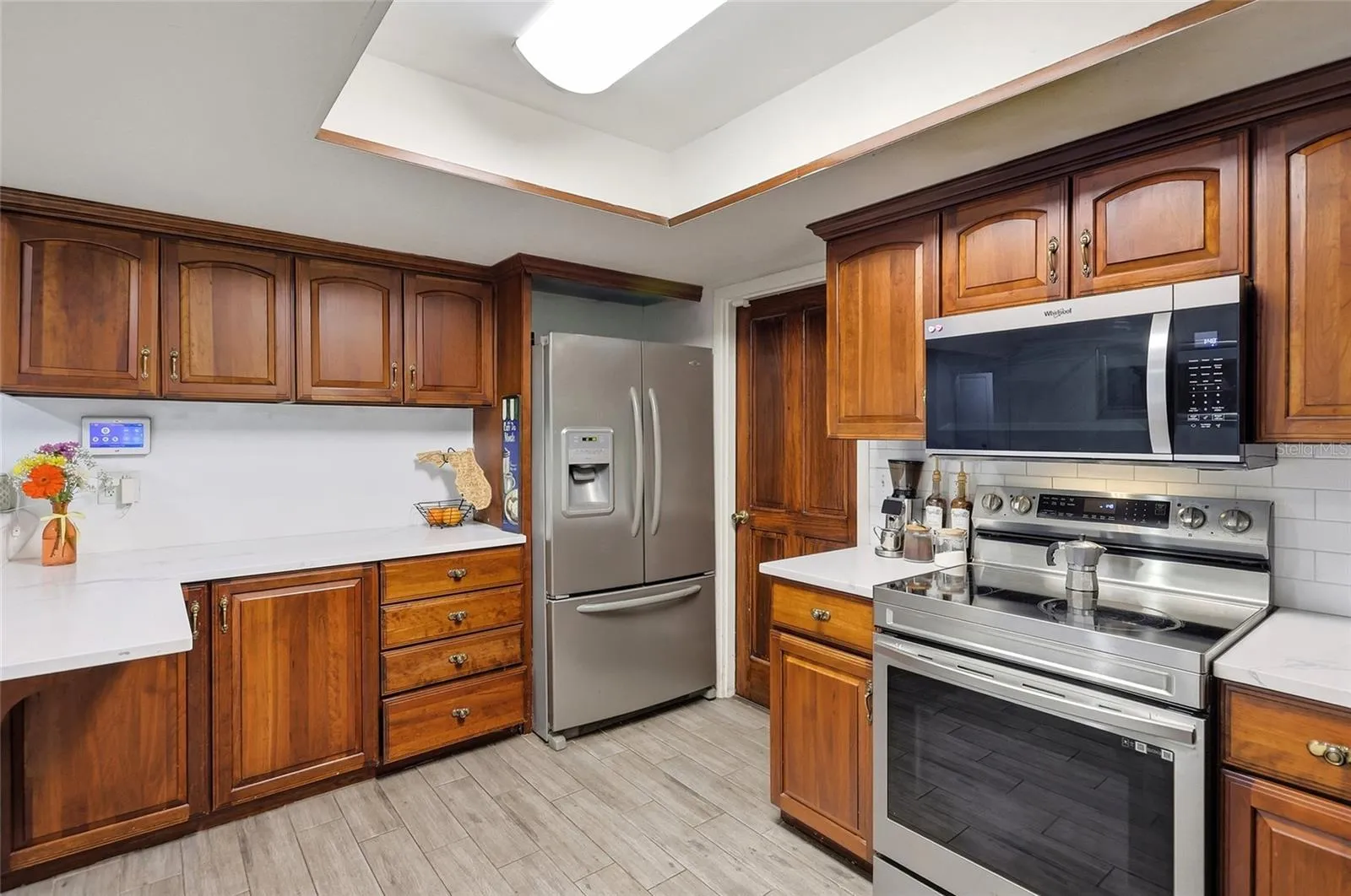 Wood cabinetry and stainless steel appliances frame the heart of the home.