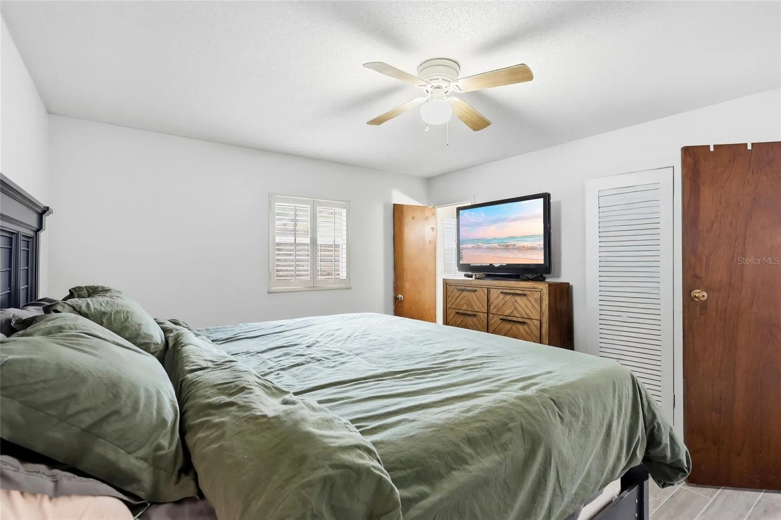 Another view of the primary bedroom highlights its layout and closet access.