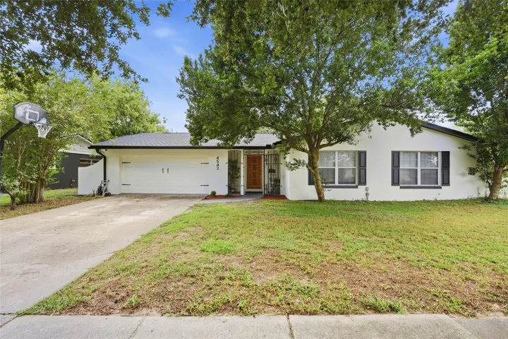 Welcome to 4542 Flagg St in Orlando, with mature trees and a two-car garage.