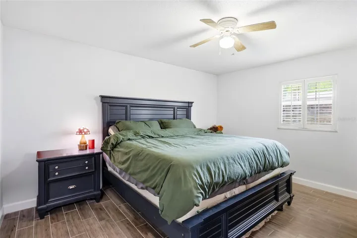 Natural light and a ceiling fan create a comfortable bedroom retreat.