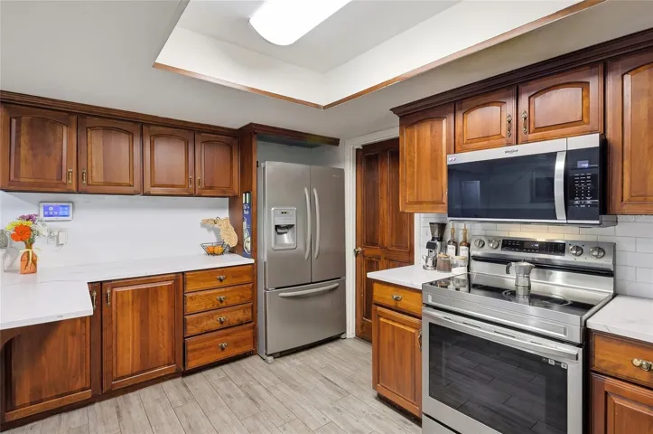 Wood cabinetry and stainless steel appliances frame the heart of the home.