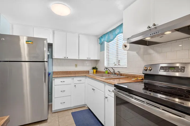 Kitchen with updated appliances and white tile back splash