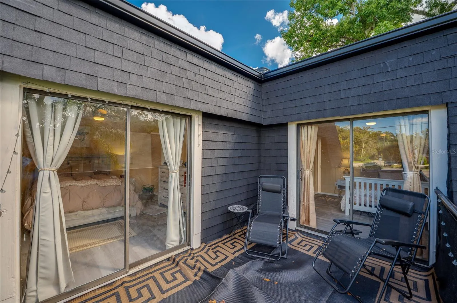 Spacious upper balcony showing dual sliding glass door entry points to the interior living spaces.