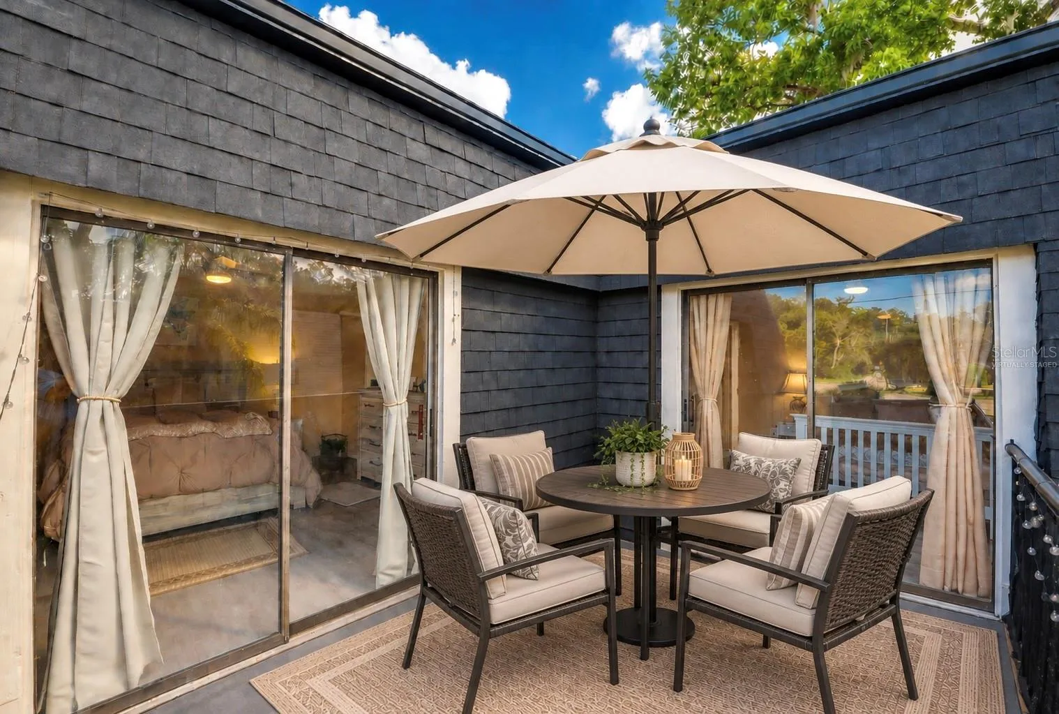Virtually staged spacious upper balcony showing dual sliding glass door entry points to the interior living spaces.