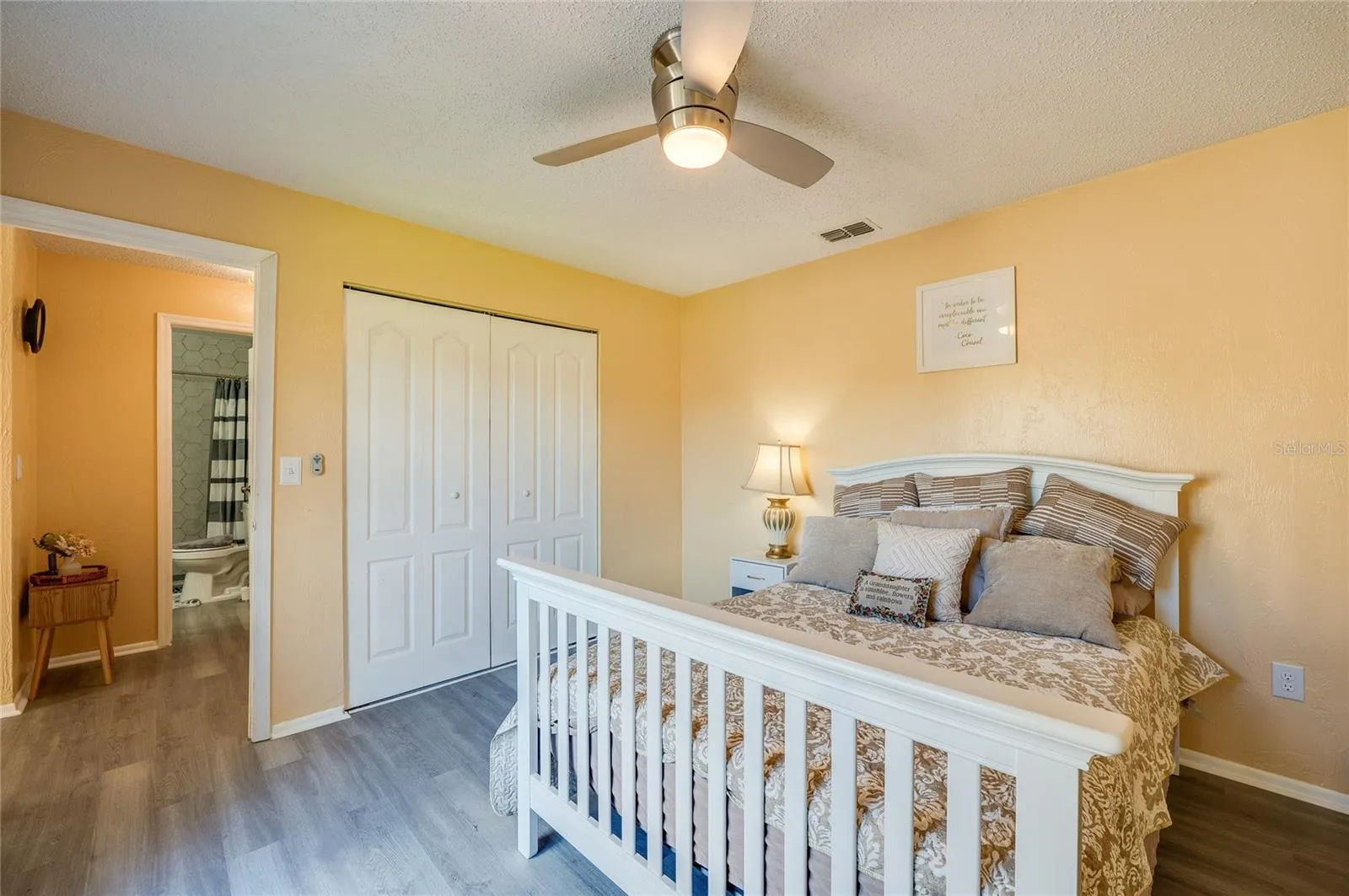 Light-filled room featuring LVP flooring, modern ceiling fan, and sliding closet doors.