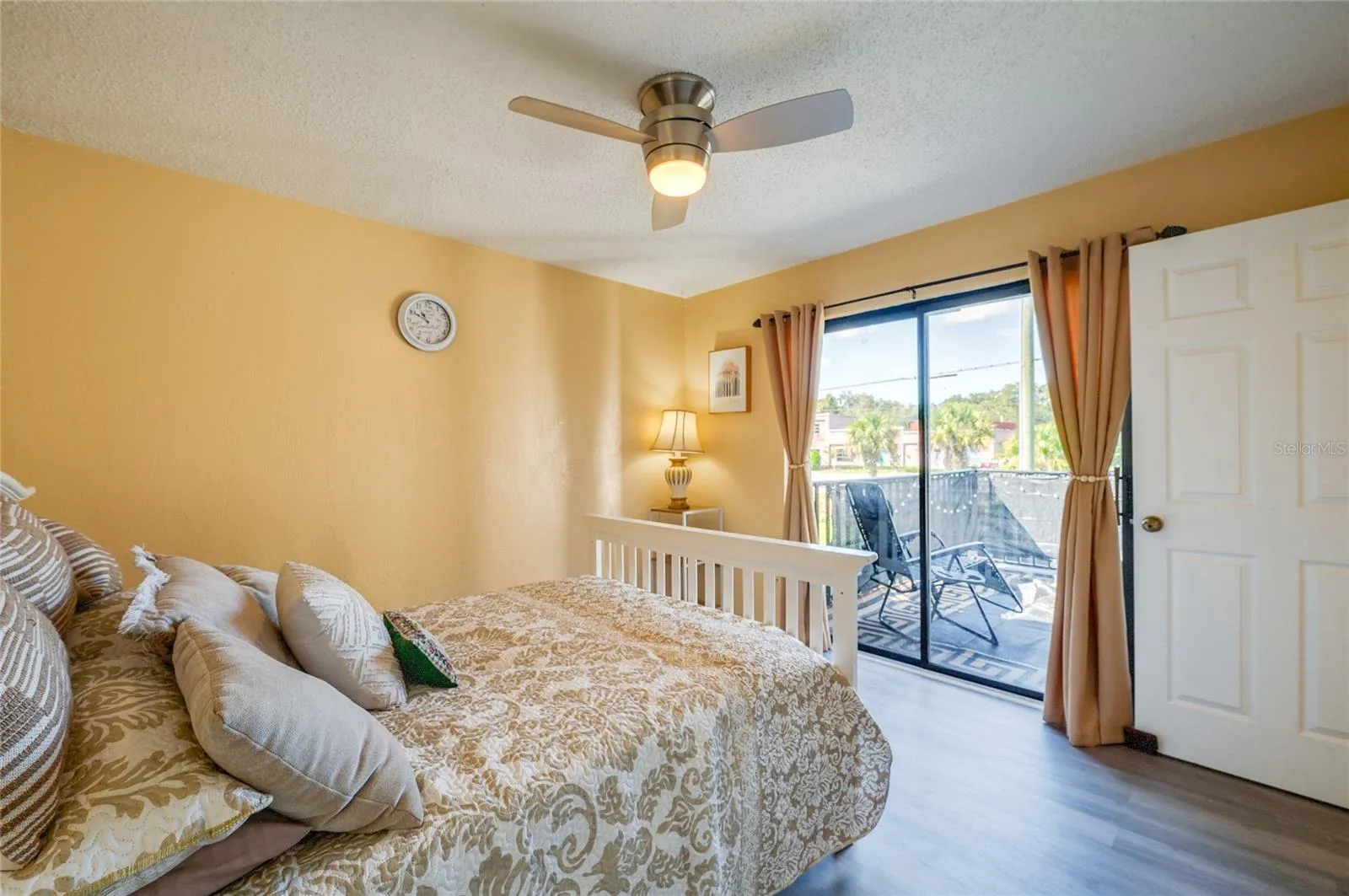 Bright room with LVP flooring, a modern ceiling fan, and sliding glass door access to a private balcony.