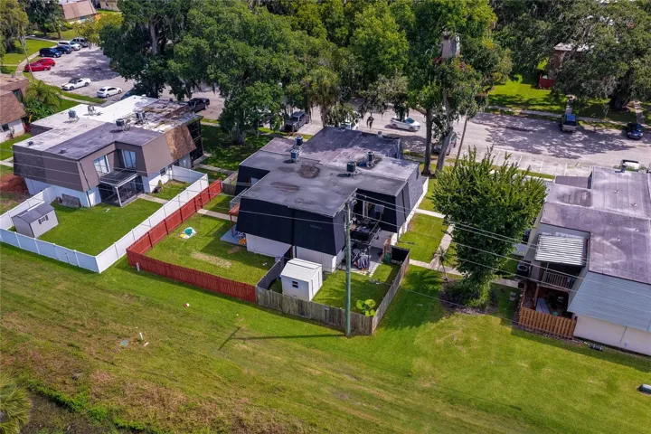 Elevated aerial view of the residential unit emphasizing its private yard, roofline layout, and mature surrounding trees.