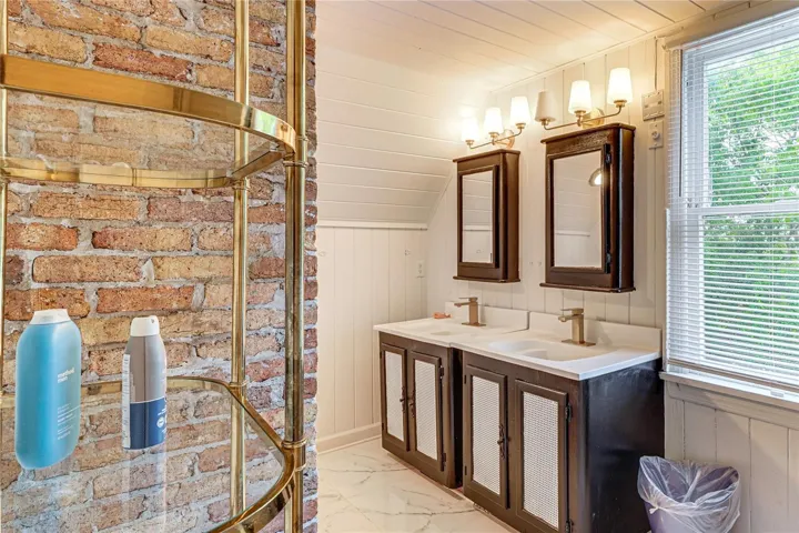 Bathroom with Double Vanity and Exposed Brick