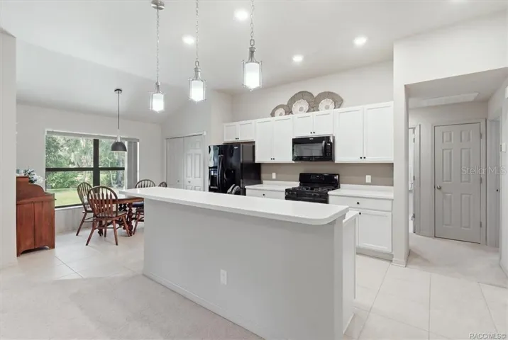 Kitchen w/ Breakfast Nook, White Cabinetry, Quartz Countertops, Black Appliances, Island w/ Raised Breakfast Bar &amp; Pantry Closet