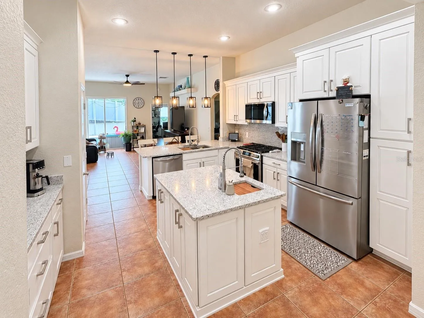 The updated kitchen features new cabinets and countertops, stainless steel appliances, soft-close cabinetry, pull-out storage for pots and pans, pull-out spice storage, Lazy Susan corner storage, additional counter seating, and a center island with prep sink.