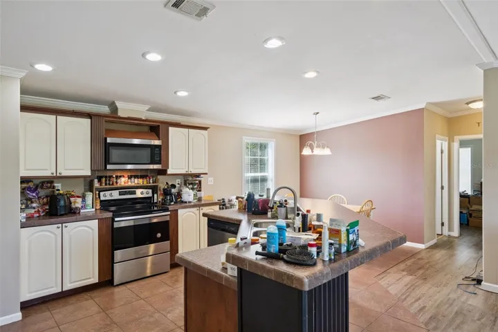 Kitchen features White Cabinetry accented with crown molding and stainless steel appliance package