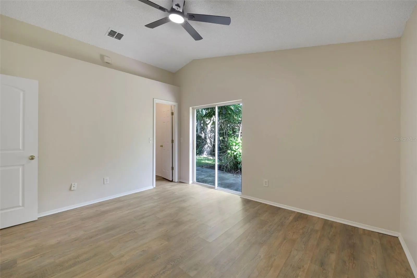 Large primary bedroom with access to the backyard