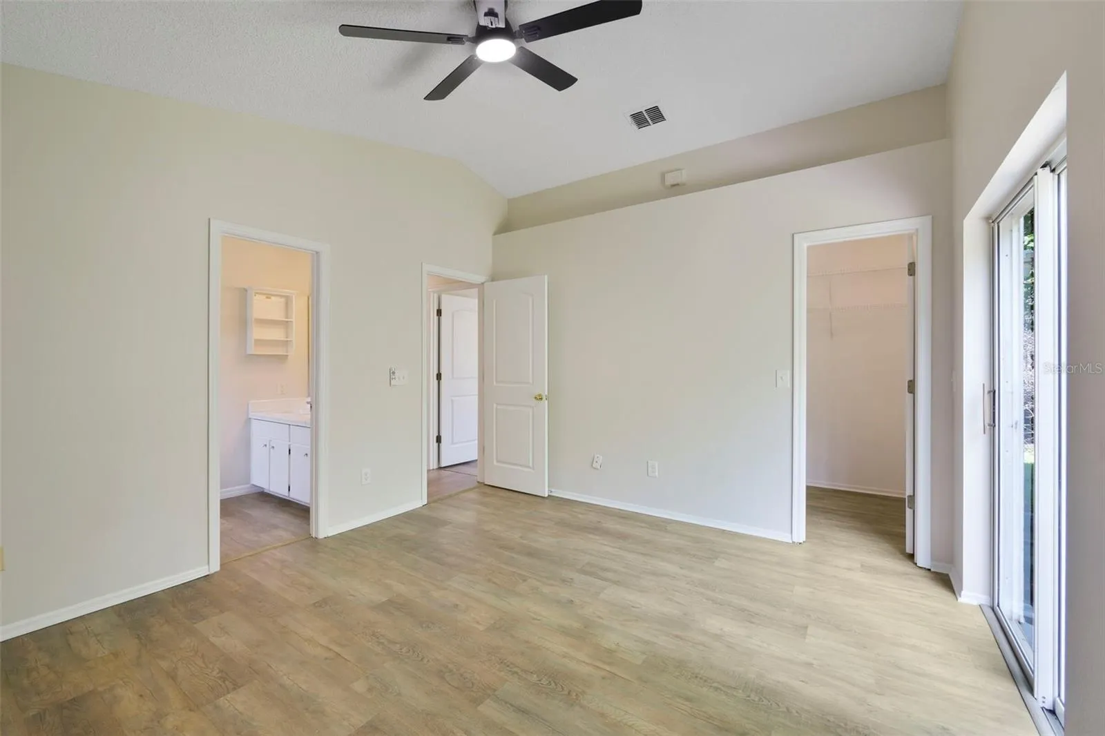 Walk-in closet and ceiling fan in the primary bedroom