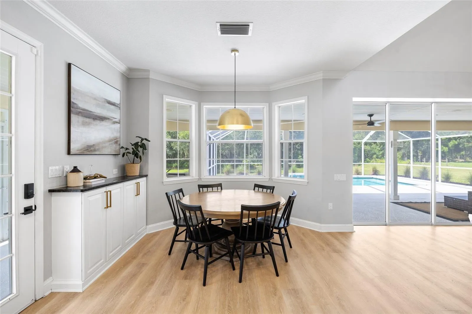 Breakfast nook area. Left door leads to screened, wrap around porch. Sliding doors lead to pool area.
