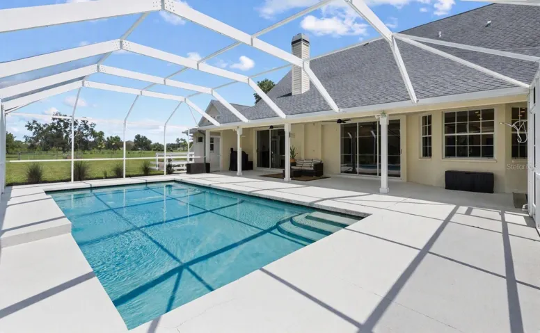 Pool area from corner, looking toward house and side garage.