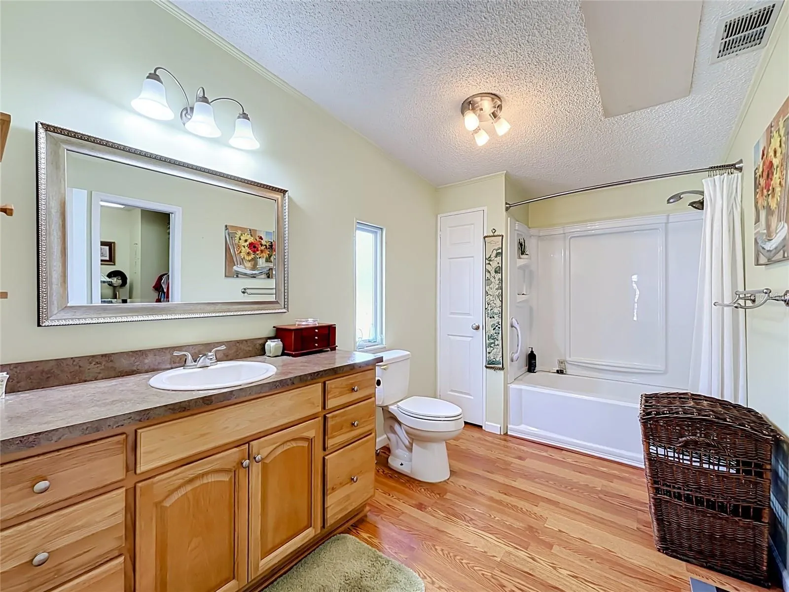 Primary bathroom benefits from tub with shower, large vanity with storage plius walk-in closet